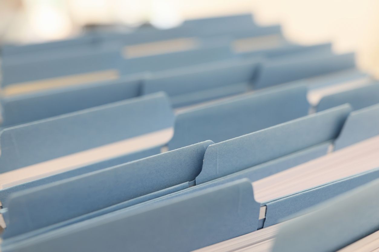 Close-up of blue file folders organized in a row, with tabs visible.