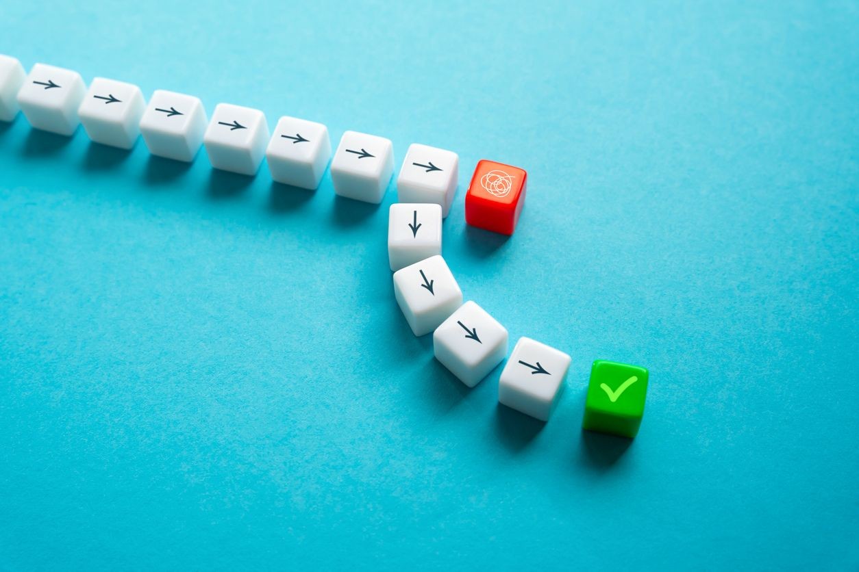 White arrow cubes forming a chain with a red and green cube on a blue background.
