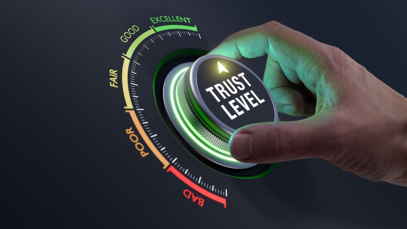 Hand turning a trust level dial from poor to excellent on a gradient gauge.